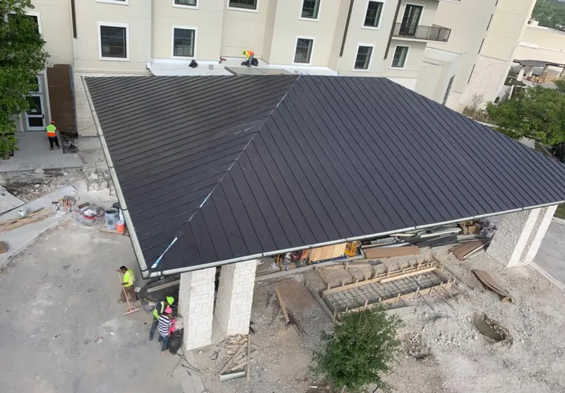 Metal roofing installation team working on a commercial building in San Carlos